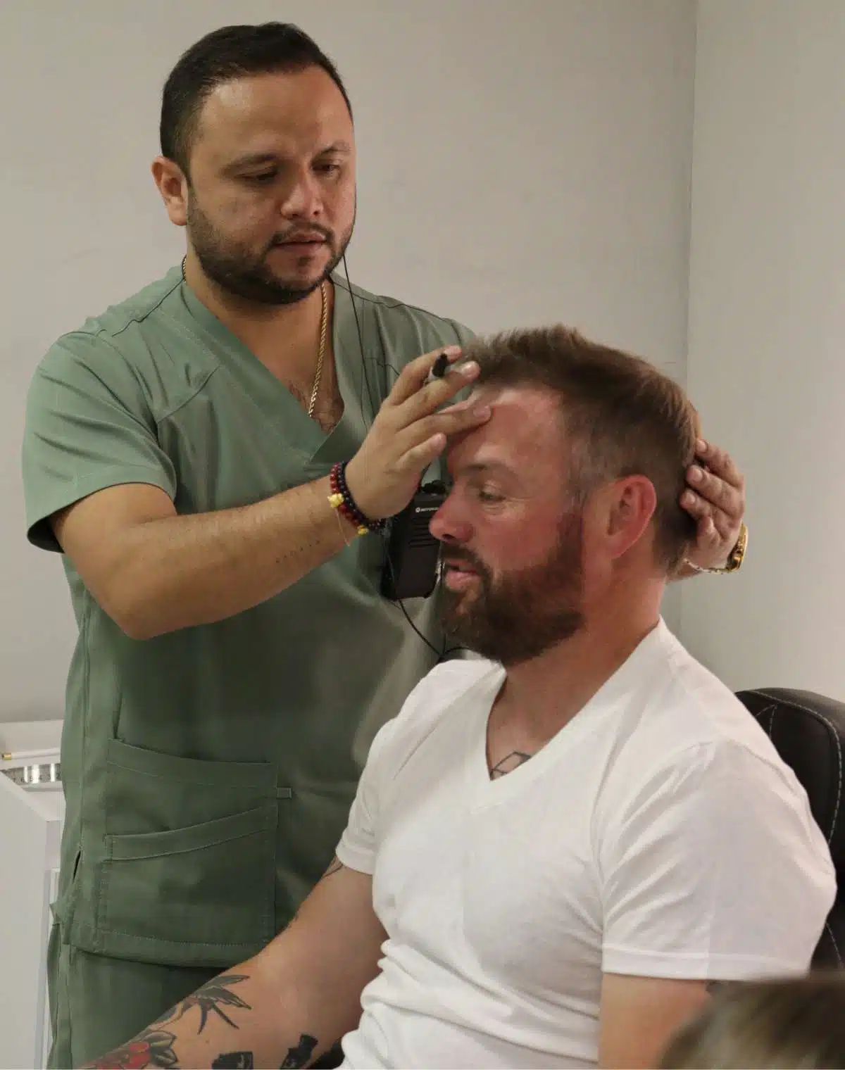 A surgeon drawing a hairline with a marker during a consultation at Encore Bogotá
